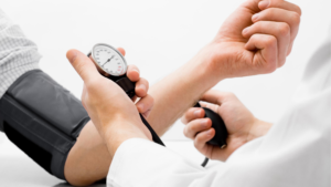 health care provider using a blood pressure cuff to read of the blood pressure