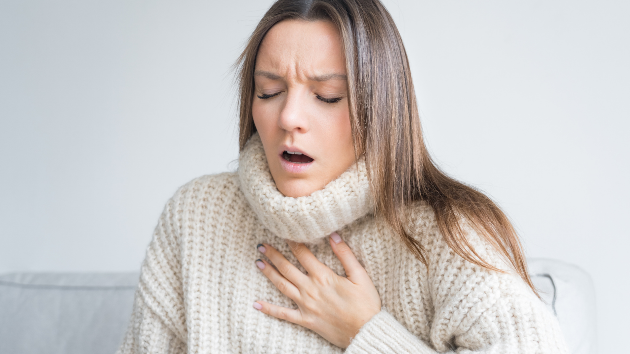 woman holding her chest with difficulty breathing