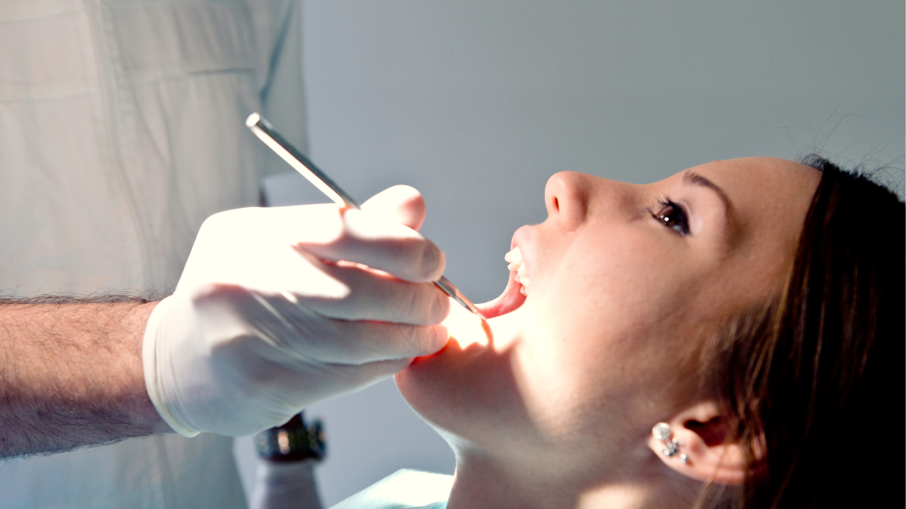 dentist examining a woman's mouth with focused light