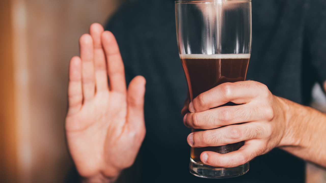 Holding up palm of hand to stop drinking alcohol
