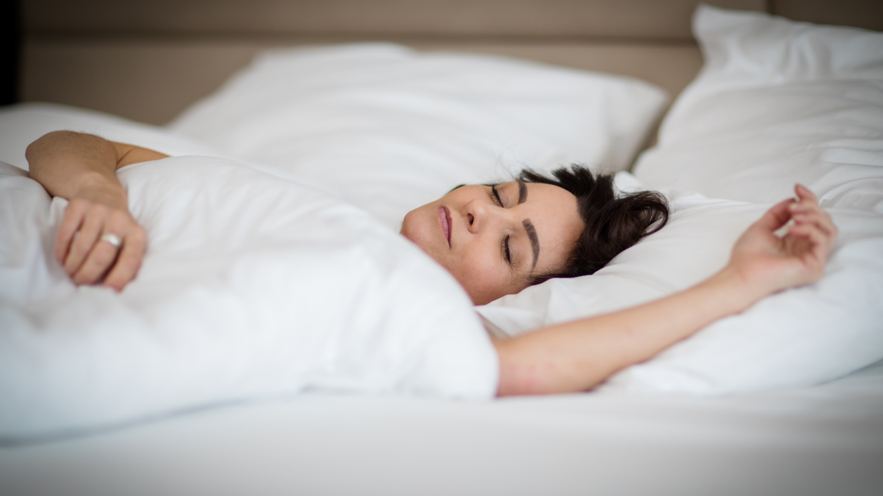 woman sleeping in bed with outstretched left arm