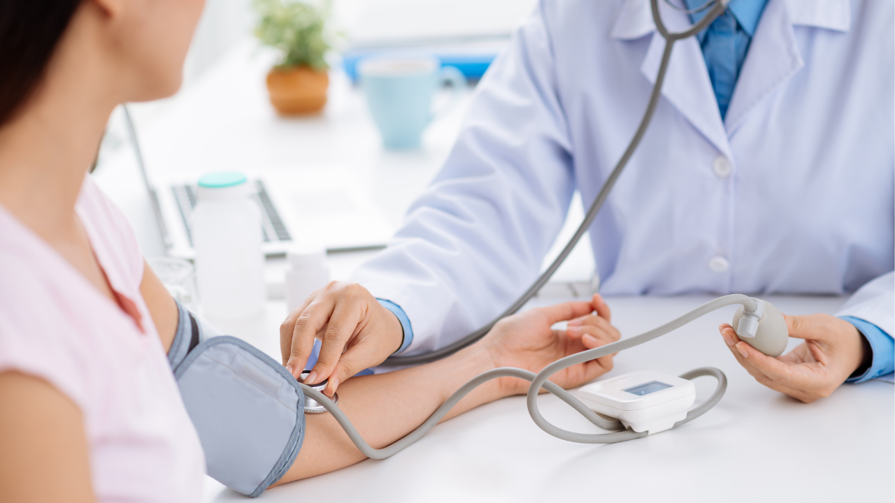 doctor measuring blood pressure using stethoscope