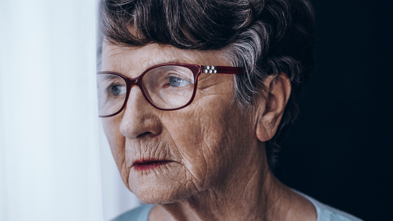 old woman with glasses staring out