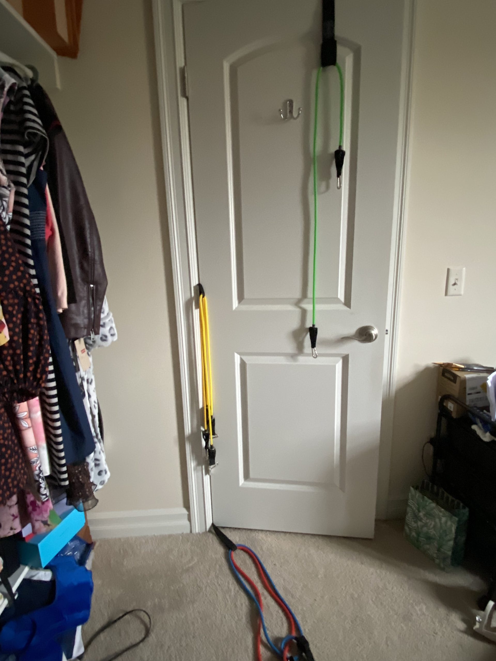 differnt coloured resistance bands hanging on a white door