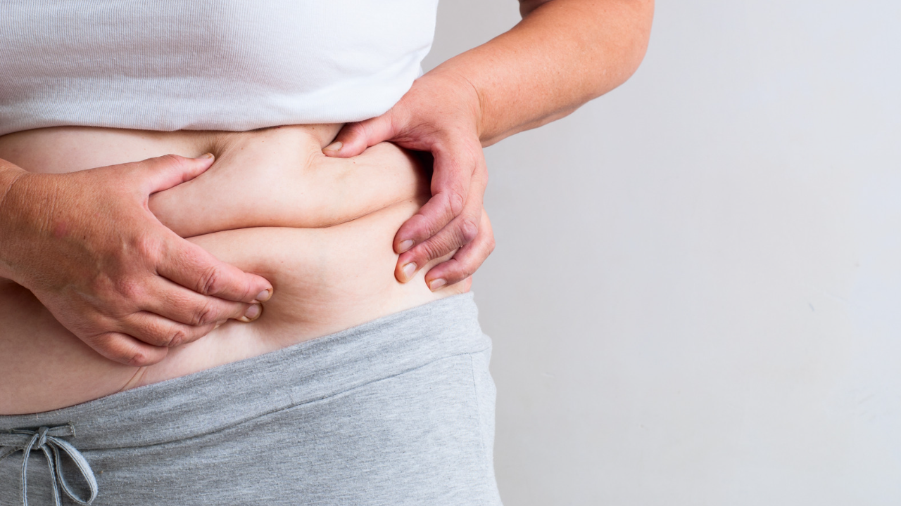 woman pressing the fat folds of her abdomen