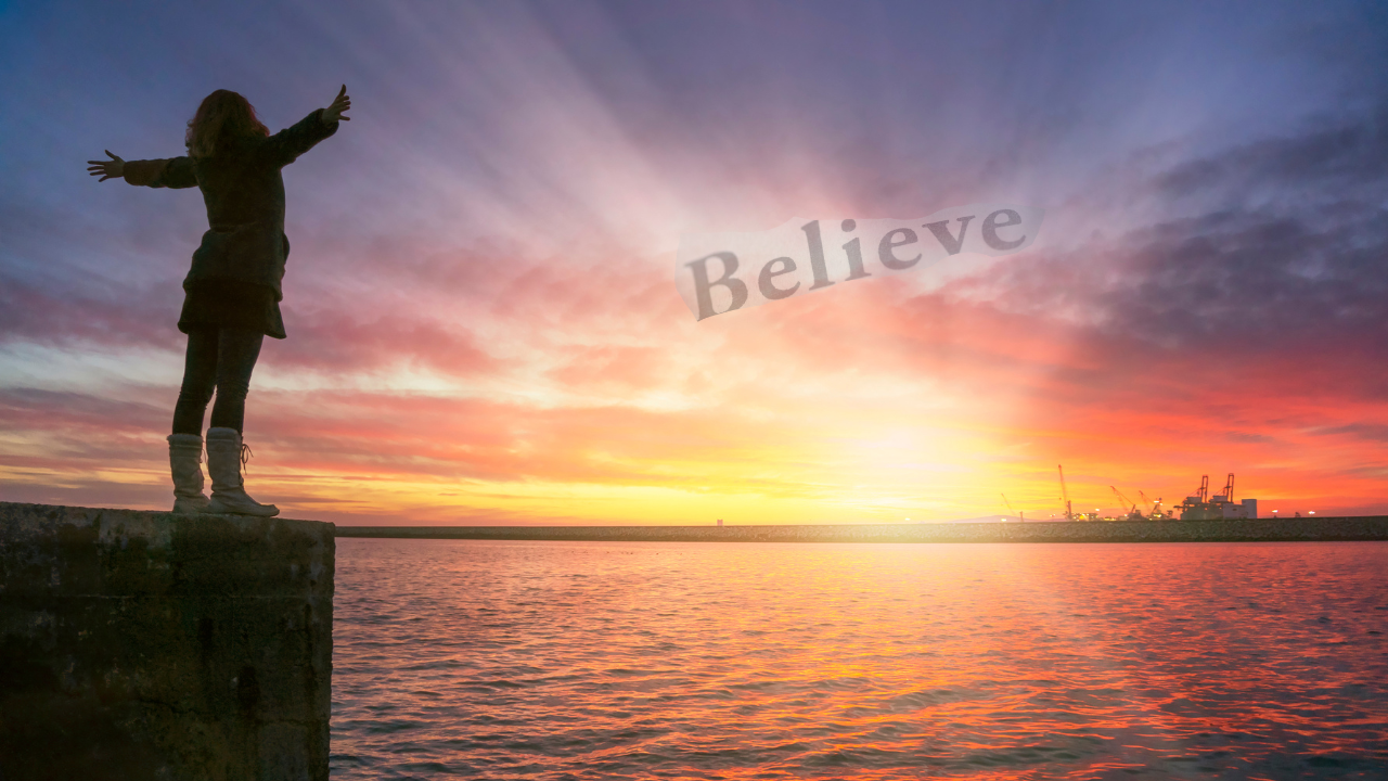 woman with outstretched arms looking at the rising sun