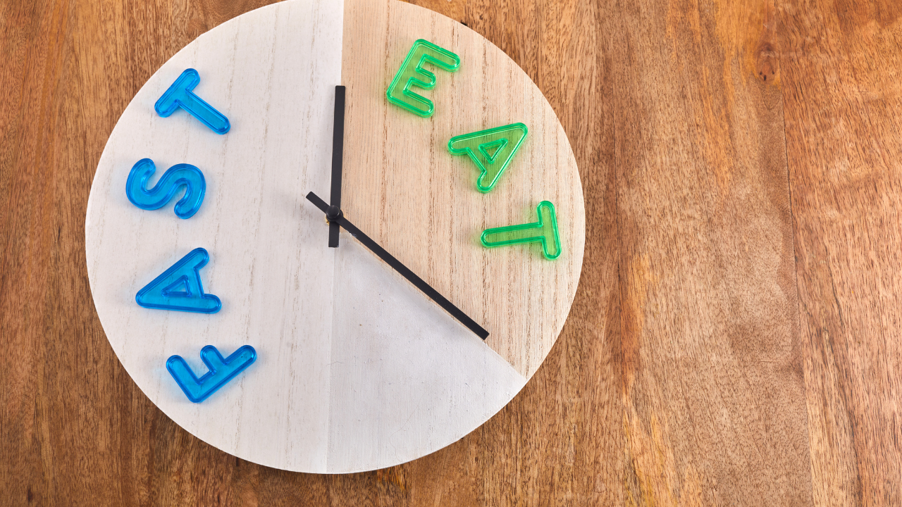 wooden clock pointing between fast and eat